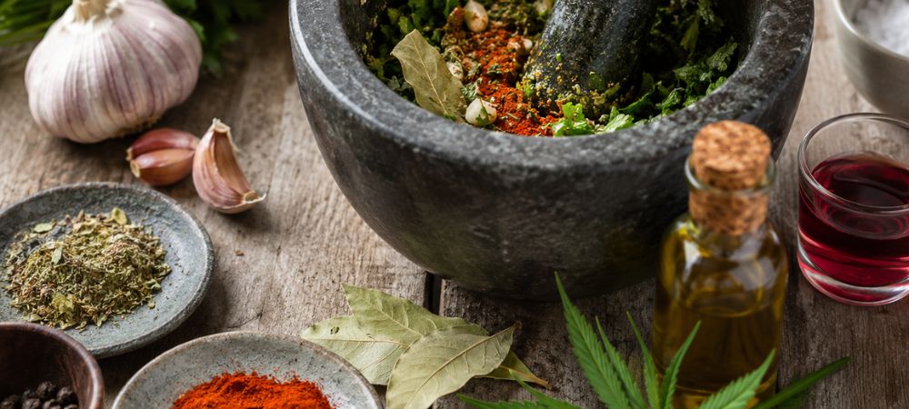 ingredientes dentro de un mortero preparados para preparar una salsa chimichurri de marihuana casera