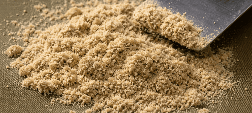 Dry Sift de color claro sobre malla de extracción con textura suelta y granulosa.