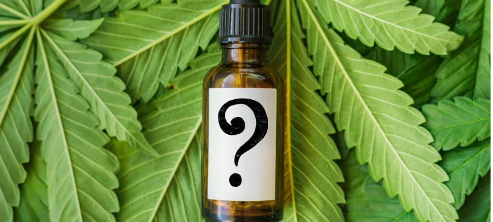 Botella de aceite de CBD sobre hojas de cannabis con símbolo de interrogación, imagen informativa sobre cómo comprar CBD online de forma segura

